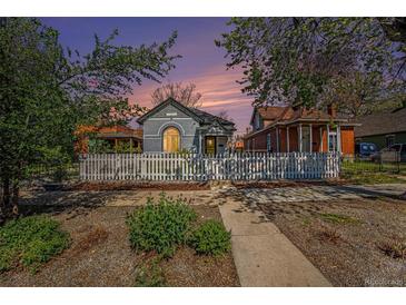 Charming home featuring a white picket fence, lush greenery, and a welcoming walkway at 3042 N Franklin St, Denver, CO 80205
