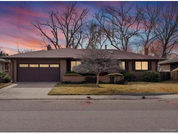 Charming brick home with a well-maintained front yard and mature trees at dusk at 2433 S Oneida St, Denver, CO 80224