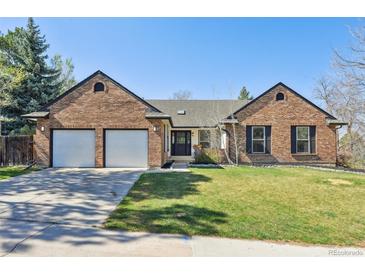Charming brick home with a well-manicured lawn, two-car garage, and inviting entryway at 6991 S Lee Way, Littleton, CO 80127