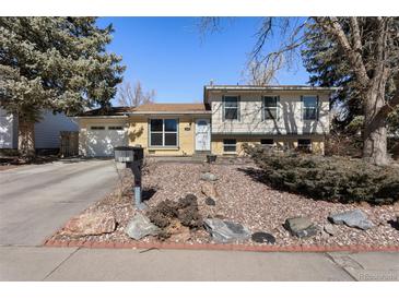 Charming split-level home boasts a well-maintained front yard and attached two-car garage at 1655 S Quintero Way, Aurora, CO 80017