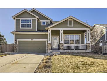 Charming two-story home with a covered porch, stone accents, and a well-maintained lawn at 1542 Cherry St, Brighton, CO 80601