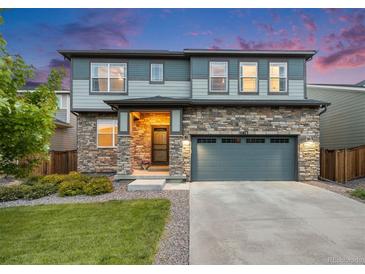 Charming two-story home with stone accents, a two-car garage, and well-maintained front yard at 16673 E Virginia Ave, Aurora, CO 80017