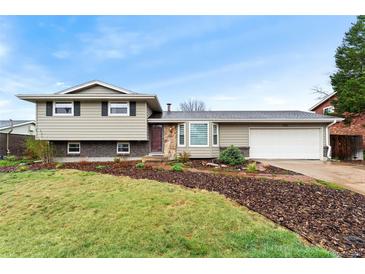 Two story home featuring stone accents, a two car garage and partially grass front yard at 7333 S Dexter Way, Centennial, CO 80122