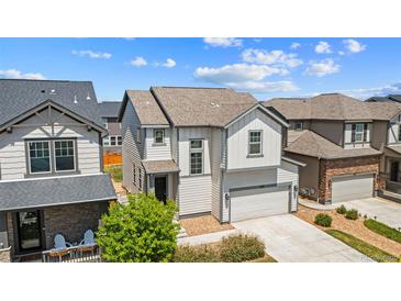 Charming two-story home with a light gray exterior, a two-car garage, and professional landscaping at 19131 E 65Th Ave, Denver, CO 80249