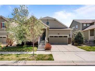 Charming home featuring a well-kept lawn, inviting porch, and a two-car garage at 827 Sundance Ln, Erie, CO 80516