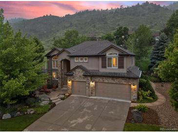 Stunning two-story home with a stone facade and a three-car garage, nestled against a scenic mountain backdrop at 19061 Eagle Ridge Dr, Golden, CO 80401