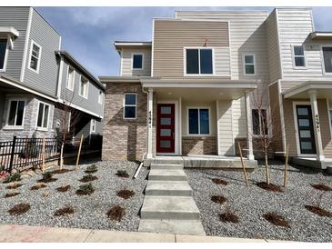 Inviting front exterior showcasing a modern townhouse with a landscaped yard and a striking red front door at 4594 S Versailles St # A, Aurora, CO 80015