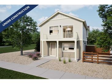 Charming two-story home with a balcony, light-colored siding, and gravel landscaping at 13585 E 103Rd Pl, Commerce City, CO 80022