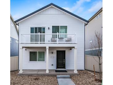 Charming two-story home featuring a quaint balcony and a well-maintained front yard with rock landscaping at 13585 E 103Rd Pl, Commerce City, CO 80022