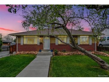 Charming brick home featuring a well-manicured lawn and a mature tree at 7861 Osceola St, Westminster, CO 80030