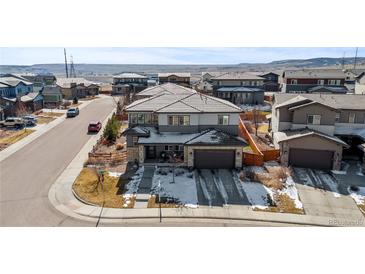 Two-story home with gray siding, stone accents, a dark roof and attached two car garage at 14100 Blue Wing Ln, Parker, CO 80134