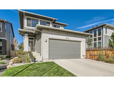 Charming two-story home featuring a well-manicured lawn and an attached two-car garage at 6893 Decatur St, Denver, CO 80221