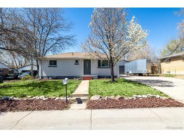 Charming home features a well-manicured lawn, tasteful landscaping, and a welcoming front entrance at 7977 Durango St, Denver, CO 80221