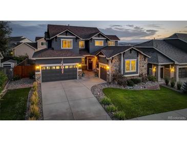 Charming two-story home with stone accents, three-car garage, and landscaped front yard at dusk at 1176 Dales Pony Dr, Castle Rock, CO 80104
