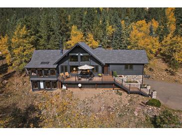 Stunning mountain home with a large deck for enjoying the surrounding wooded views in the fall at 239 Aspen Pl, Evergreen, CO 80439