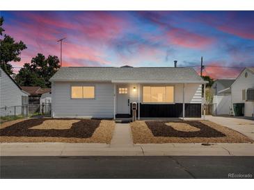 Charming home with a white exterior, black accents, manicured front yard, and inviting entrance at 7830 Ladore St, Commerce City, CO 80022