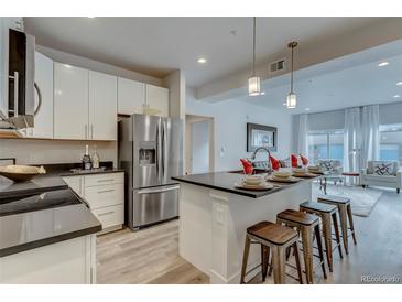 Modern kitchen features stainless steel appliances and an island with seating at 14936 E Hampden Ave # 202, Aurora, CO 80014