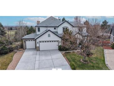 Aerial view of a home with large driveway, three-car garage and a manicured lawn at 5398 S Jay Dr, Littleton, CO 80123