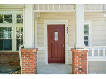 Charming home featuring a deep red front door framed by brick and white columns at 640 S Yarrow St, Lakewood, CO 80226