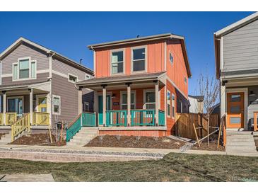 Charming two-story home featuring a cozy porch, colorful accents, and well-maintained landscaping at 10331 E 62Nd Pl, Denver, CO 80238