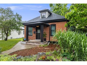 Charming brick home featuring a black trimmed porch and inviting landscaping at 4673 Bryant St, Denver, CO 80211