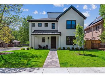 Charming two-story home with a bright white exterior, dark accents, a manicured lawn, and a stone walkway at 1195 S Milwaukee St, Denver, CO 80210