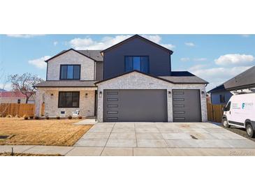 Two-story house with gray and white exterior, two-car garage, and landscaping at 3343 S Newcombe St, Lakewood, CO 80227
