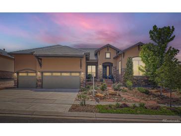 Charming single-Gathering home featuring a stone and stucco facade, three-car garage, and a well-manicured front yard at 15637 Deer Mountain Cir, Broomfield, CO 80023