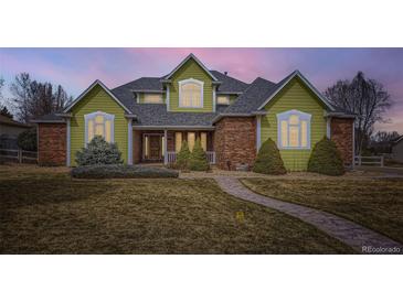 Charming home featuring brick accents, manicured landscaping and an inviting stone pathway at 6885 Saddleback Ave, Firestone, CO 80504