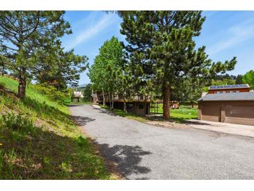 Scenic view of home's driveway, two car detached garage and a cozy deck at 30221 Stagecoach Blvd, Evergreen, CO 80439