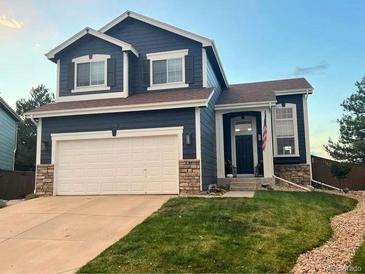 Charming two-story home boasts a well-manicured lawn and attached two-car garage at 4241 Brookwood Pl, Highlands Ranch, CO 80130