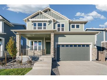 Charming two-story home with a welcoming front porch and a two-car garage at 21127 E 62Nd Dr, Aurora, CO 80019