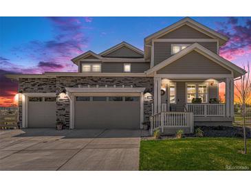 Charming two-story home features a stone facade, three-car garage, and inviting front porch with landscaped yard at dusk at 1282 Eldorado Dr, Superior, CO 80027