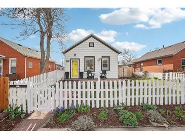 Quaint home with a well manicured lawn framed by a white picket fence and mature tree at 4883 Perry St, Denver, CO 80212