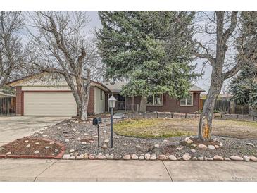 Inviting single-story brick home with a manicured front yard and mature trees at 2056 S Newark Way, Aurora, CO 80014