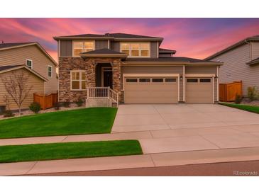 Charming two-story home with a stone facade, well-manicured lawn, and a spacious two car garage at 80 Back Nine Dr, Castle Pines, CO 80108