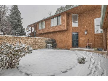 Snowy backyard with stone wall and small trees at 12136 E 2Nd Dr, Aurora, CO 80011