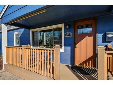 Charming blue home featuring a covered front porch, a welcoming front door, and a well-manicured entrance at 1390 S Glencoe St, Denver, CO 80222
