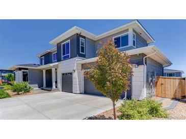 Beautiful two-story home featuring gray siding, white stone accents, and a three-car garage at 14290 Hop Clover St, Parker, CO 80134