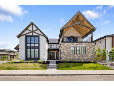 Stunning two-story home with a stone facade and modern architectural details in a manicured lawn at 3147 Juniper Ct, Golden, CO 80401