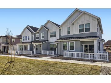 Charming townhomes featuring modern architecture and a well-manicured lawn at 14587 W 90Th Ln # B, Arvada, CO 80005