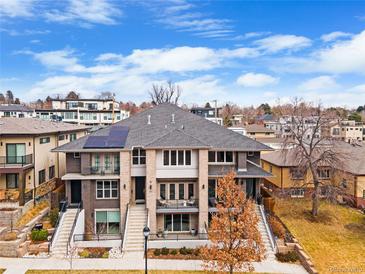 Beautiful townhouse featuring a gray roof, brick facade, and balconies in a vibrant neighborhood with blue skies at 32 Jackson St, Denver, CO 80206