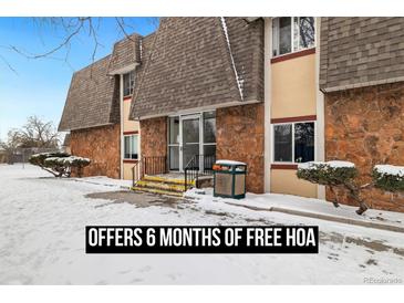 Attractive condo building featuring a stone facade, brown shingle roof and inviting entryway at 9650 Huron St # 22, Thornton, CO 80260