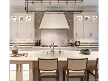 Gourmet kitchen features custom cabinets, marble backsplash, and professional-grade appliances at 2260 S Jackson St, Denver, CO 80210