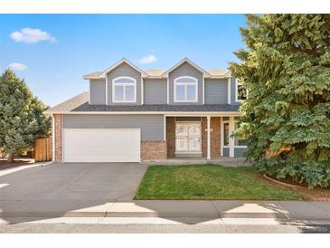 Charming two-story home featuring a well-manicured lawn, brick accents, and an attached two-car garage at 10894 Depew Pl, Westminster, CO 80020
