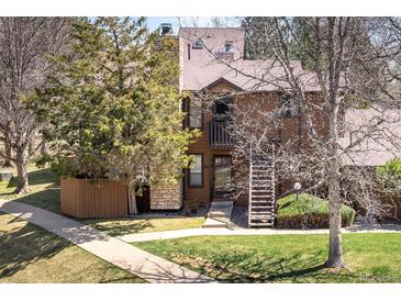 Charming townhome with a cozy front entrance, a lush lawn, and mature trees at 6251 Willow Ln, Boulder, CO 80301