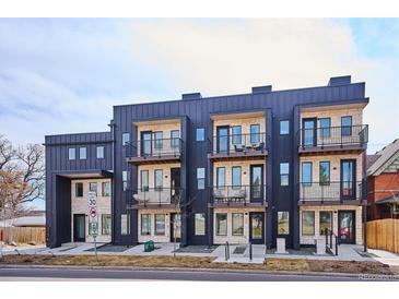 Modern condo building with stone accents, black trim, balconies, and well-maintained landscaping at 5128 W 26Th Ave # 207, Denver, CO 80212