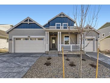 Charming two-story home with a covered porch, two-car garage, and manicured front yard at 39876 Floyd St, Elizabeth, CO 80107