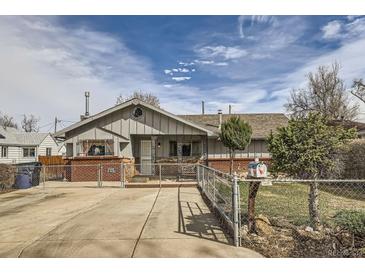 A charming one-story home with a fenced yard, inviting curb appeal, and driveway at 828 S Osceola St, Denver, CO 80219