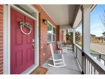 Inviting covered porch with rocking chairs and brick facade at 5404 W 95Th Pl, Westminster, CO 80020